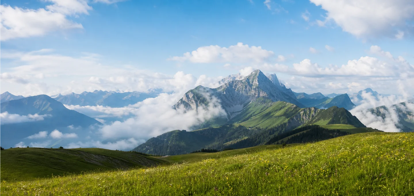 Sommerliche Berglandschaft mit Sonne und luftigen Wolken